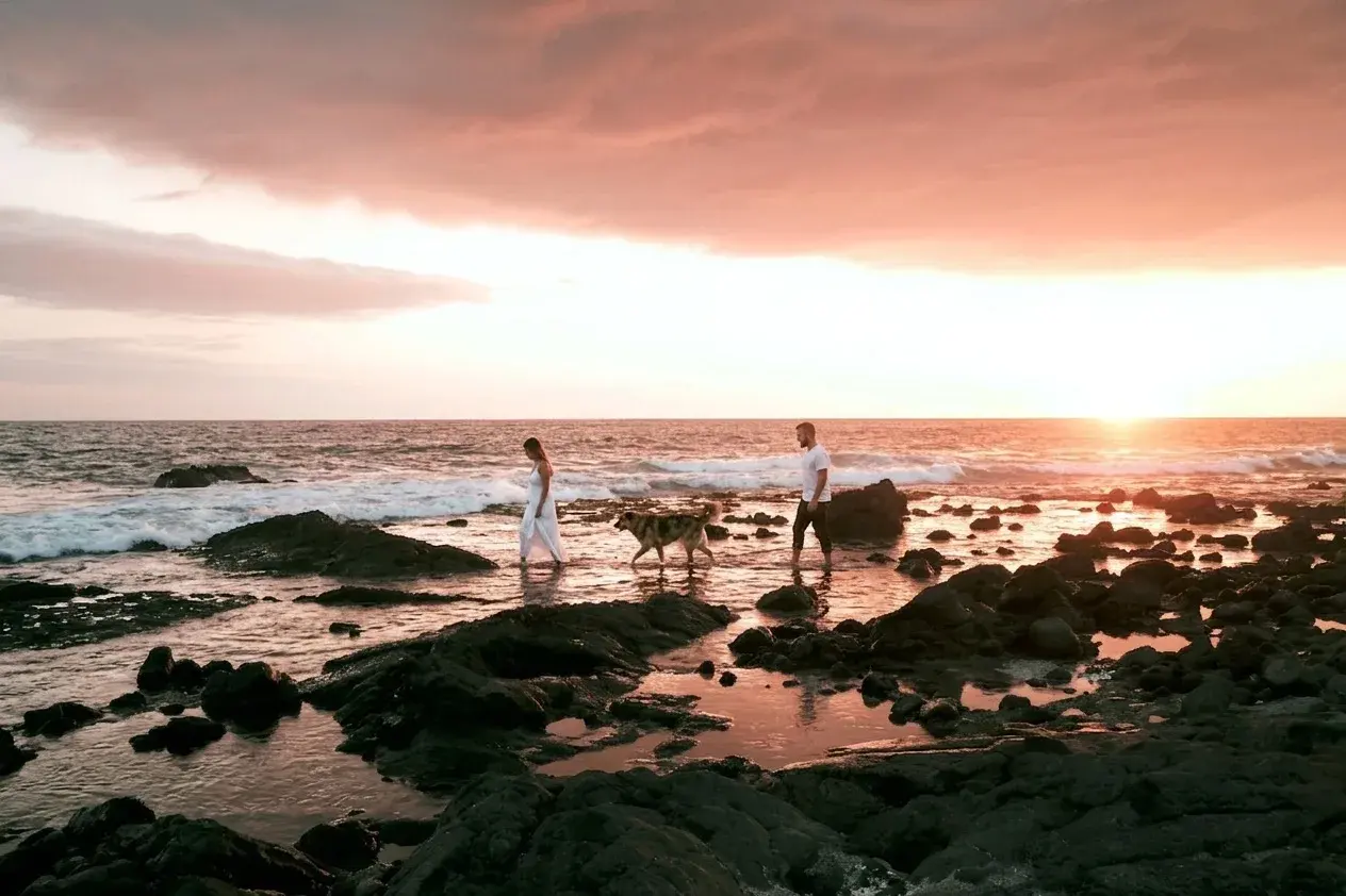 Couple on pink salt sand at sunset, Big Island